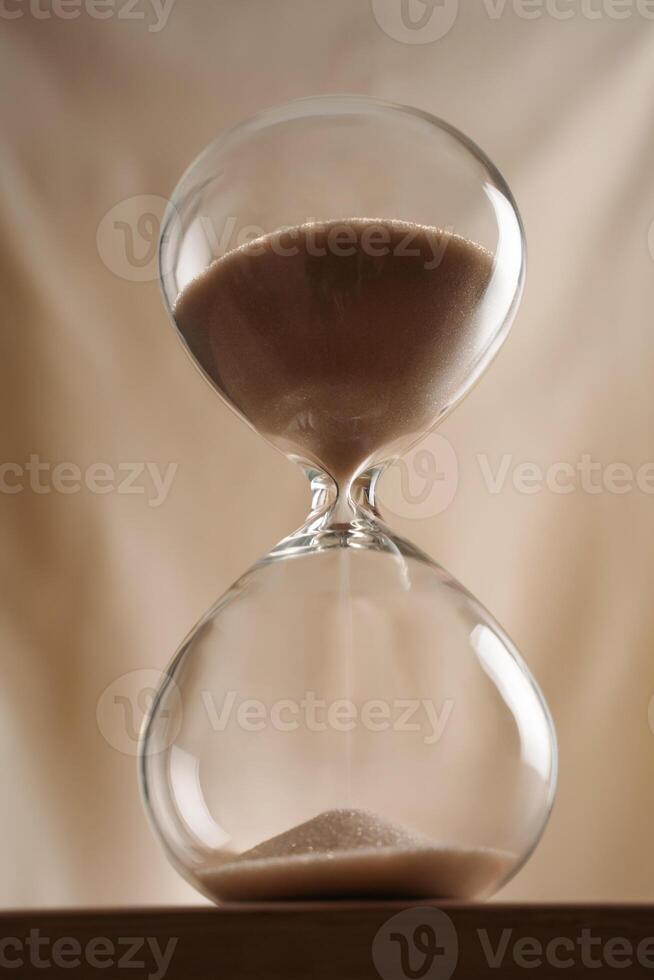 Minimalist Glass full time Hourglass on Wooden Surface with Beige Background hero shot low-key photo