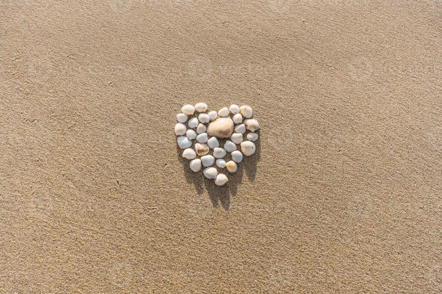 Sandy Background with Heart Made of Shells photo