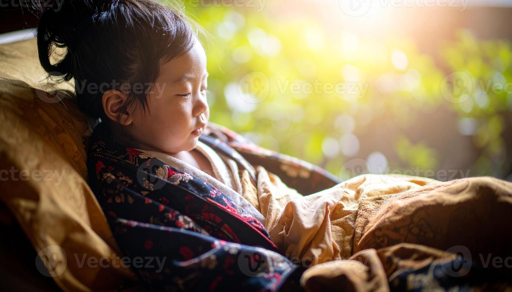 A Young Child's Tranquil Slumber in a Warm, Golden Morning Glow photo