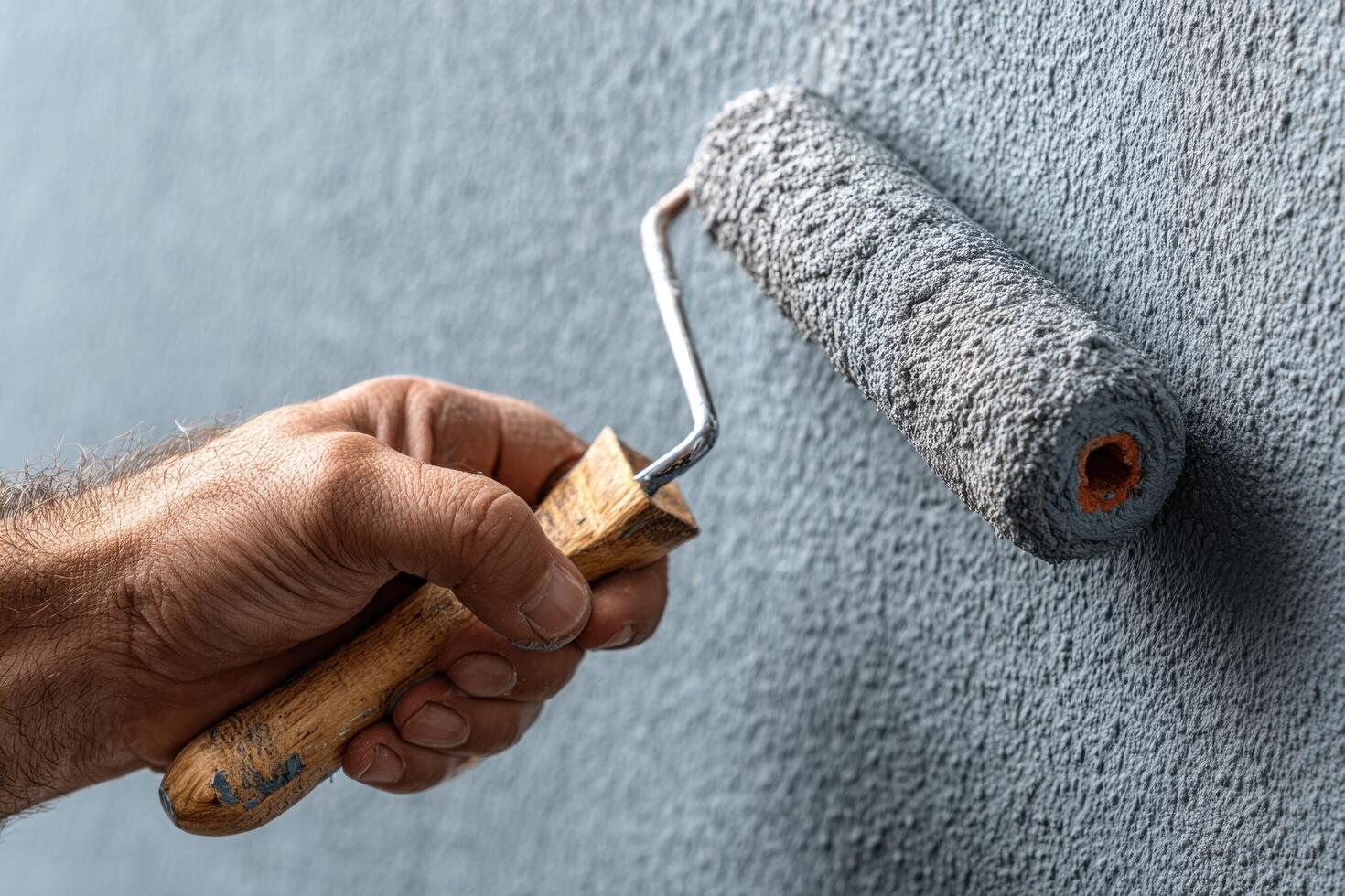 A man is painting a wall with a roller photo