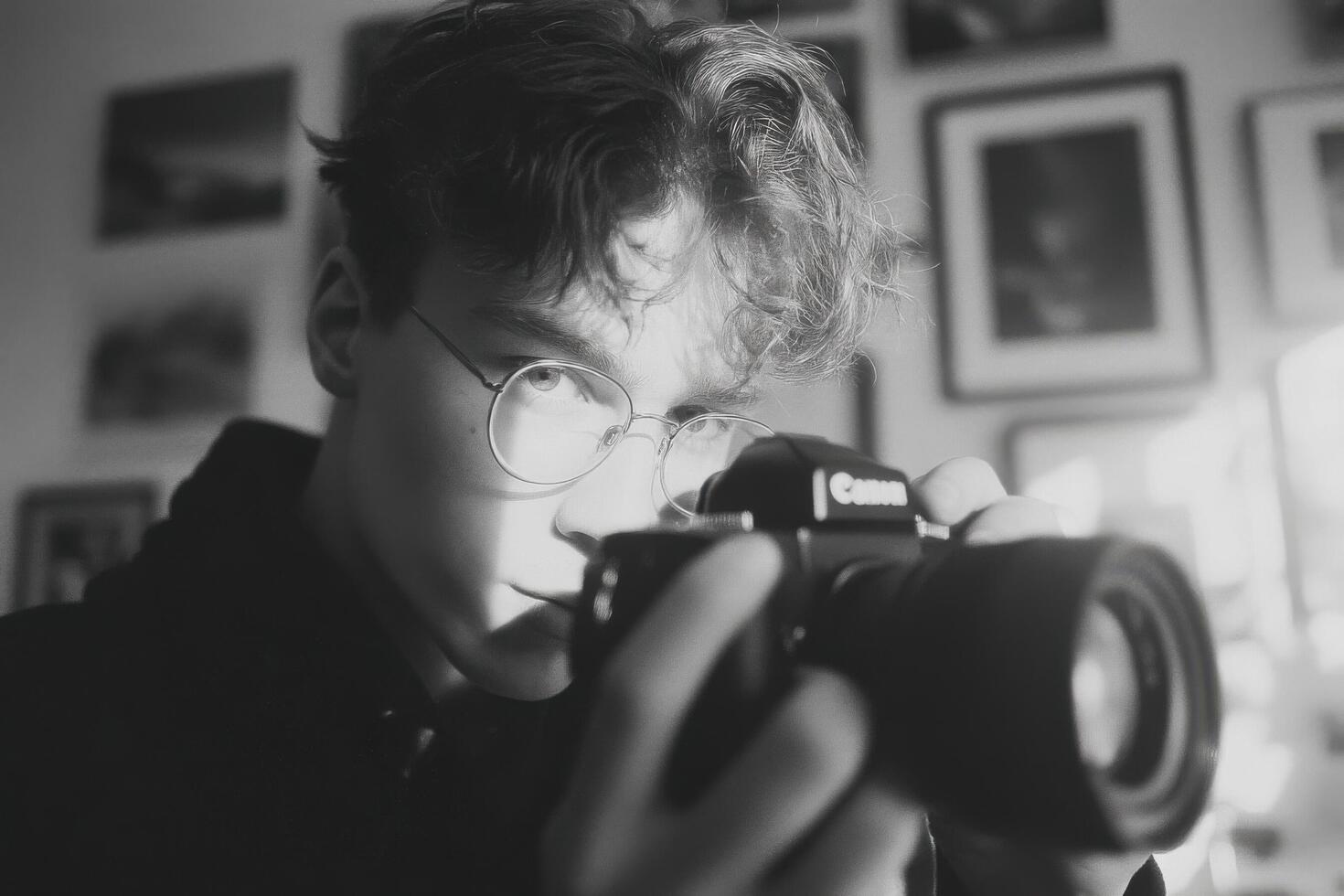 A young man with glasses taking a photo with a camera