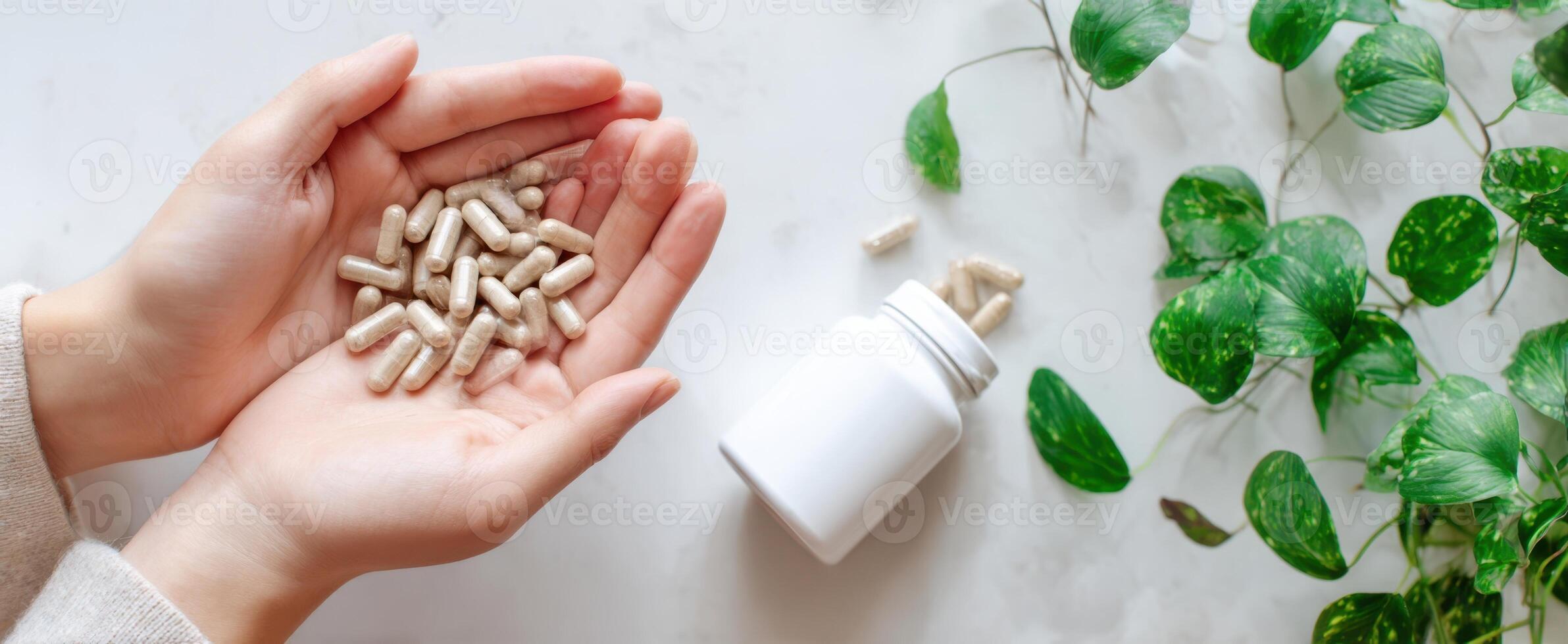 The hands holding dietary supplements with greenery in the background. photo
