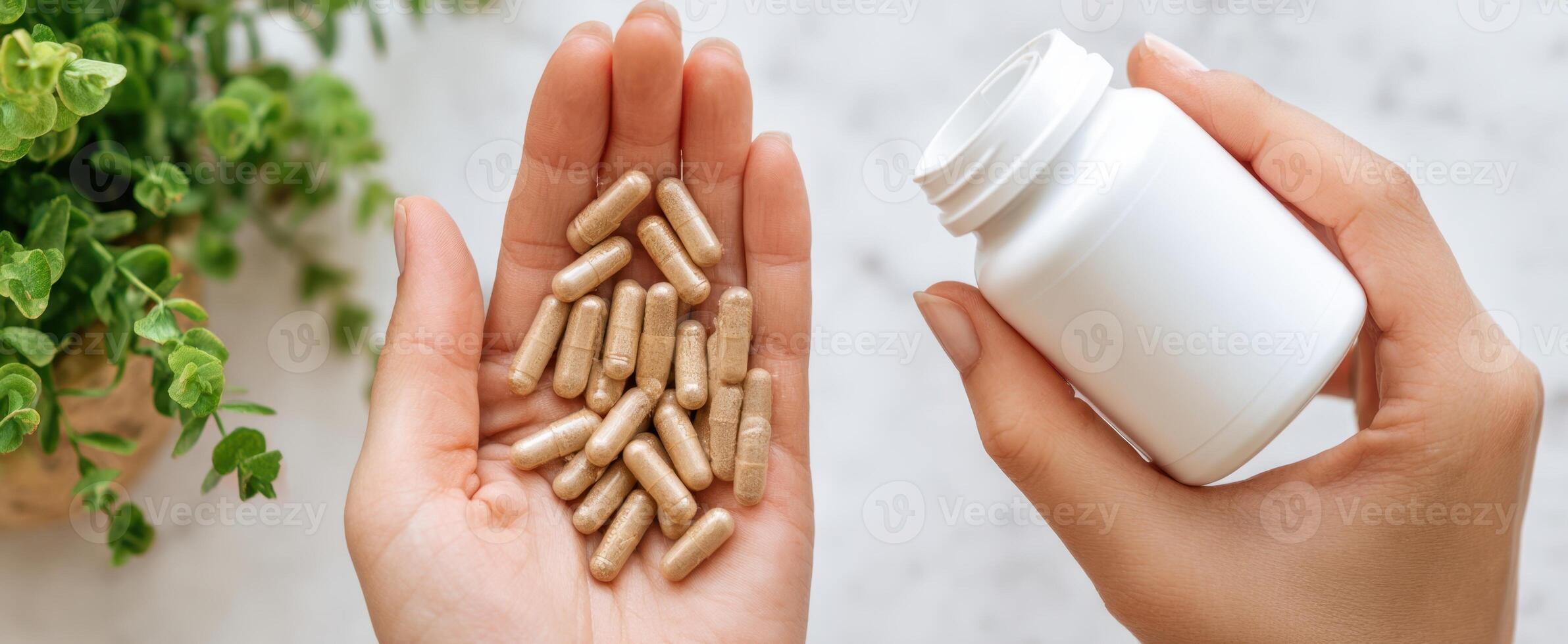 The hand holding dietary capsules with a white bottle and greenery in the background. photo