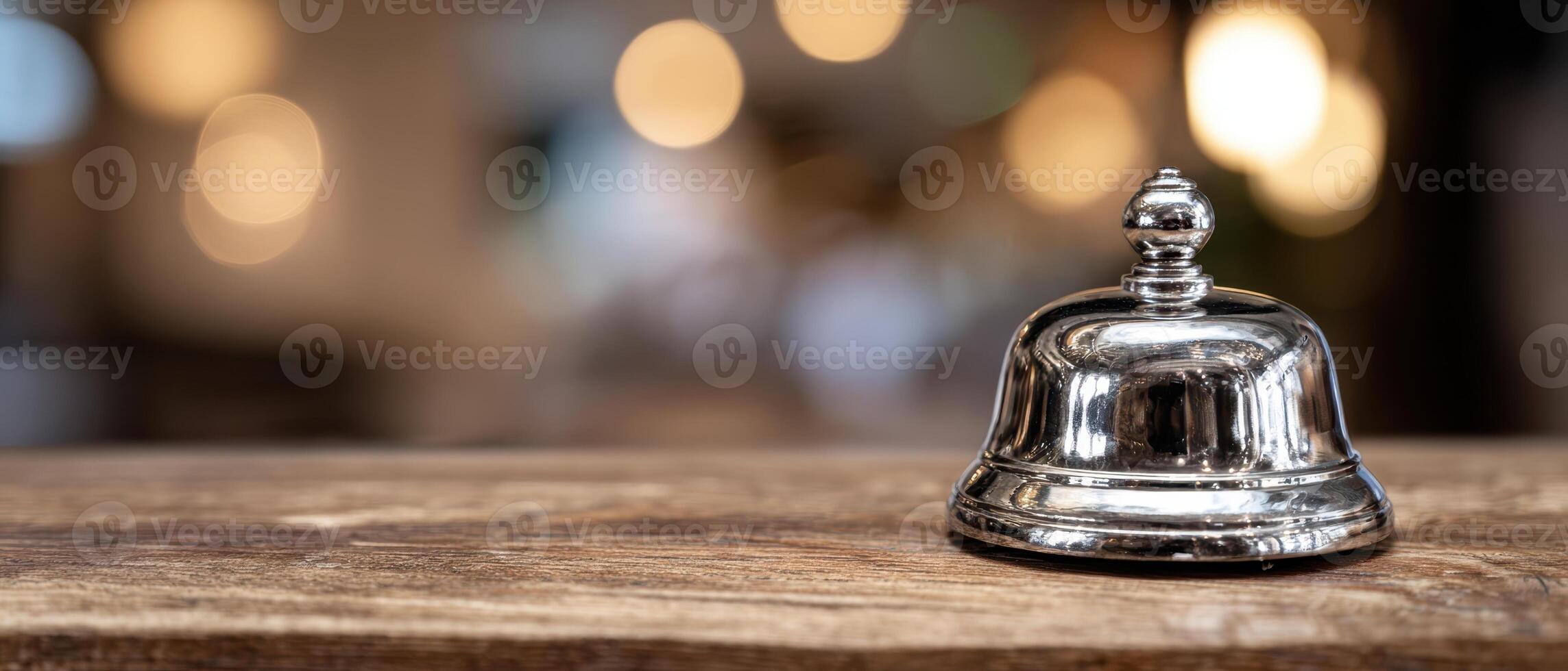 The shiny bell on a wooden table with a blurred background. photo