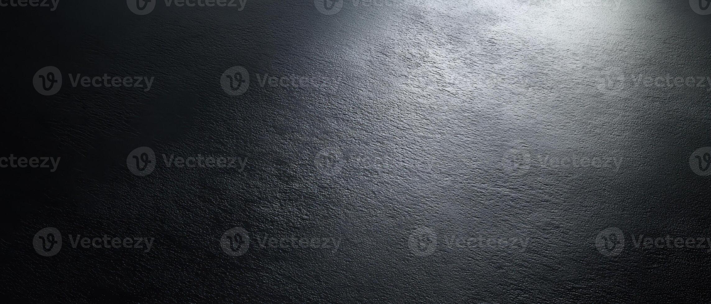 The smooth black surface illuminated by subtle highlights and shadows. photo