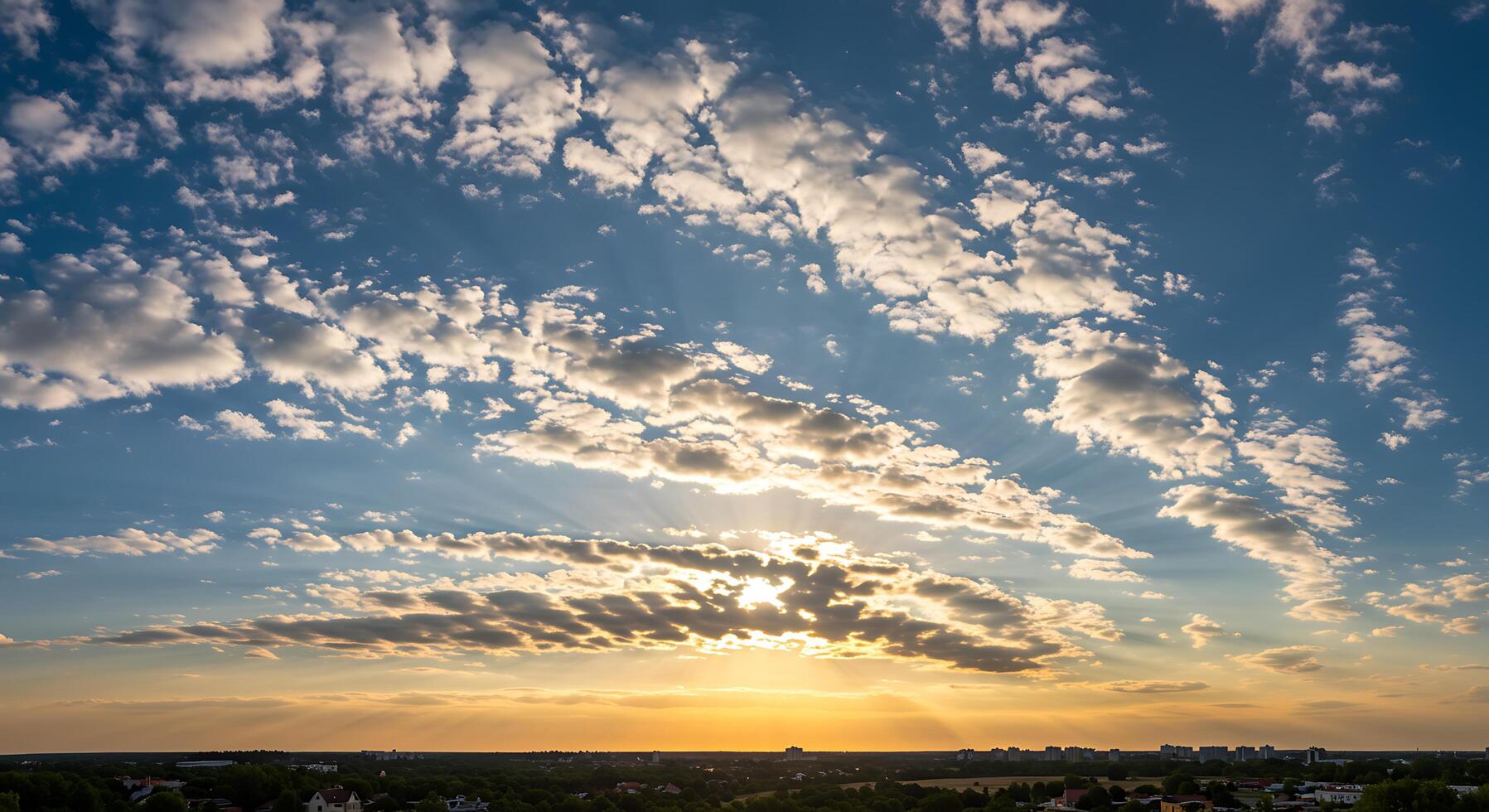 A sunset with clouds and a plane flying over a city photo