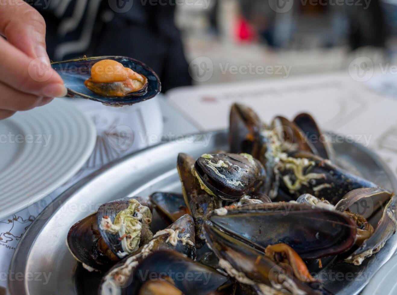 A delectable dish of fresh mussels served with a slice of lemon, photo