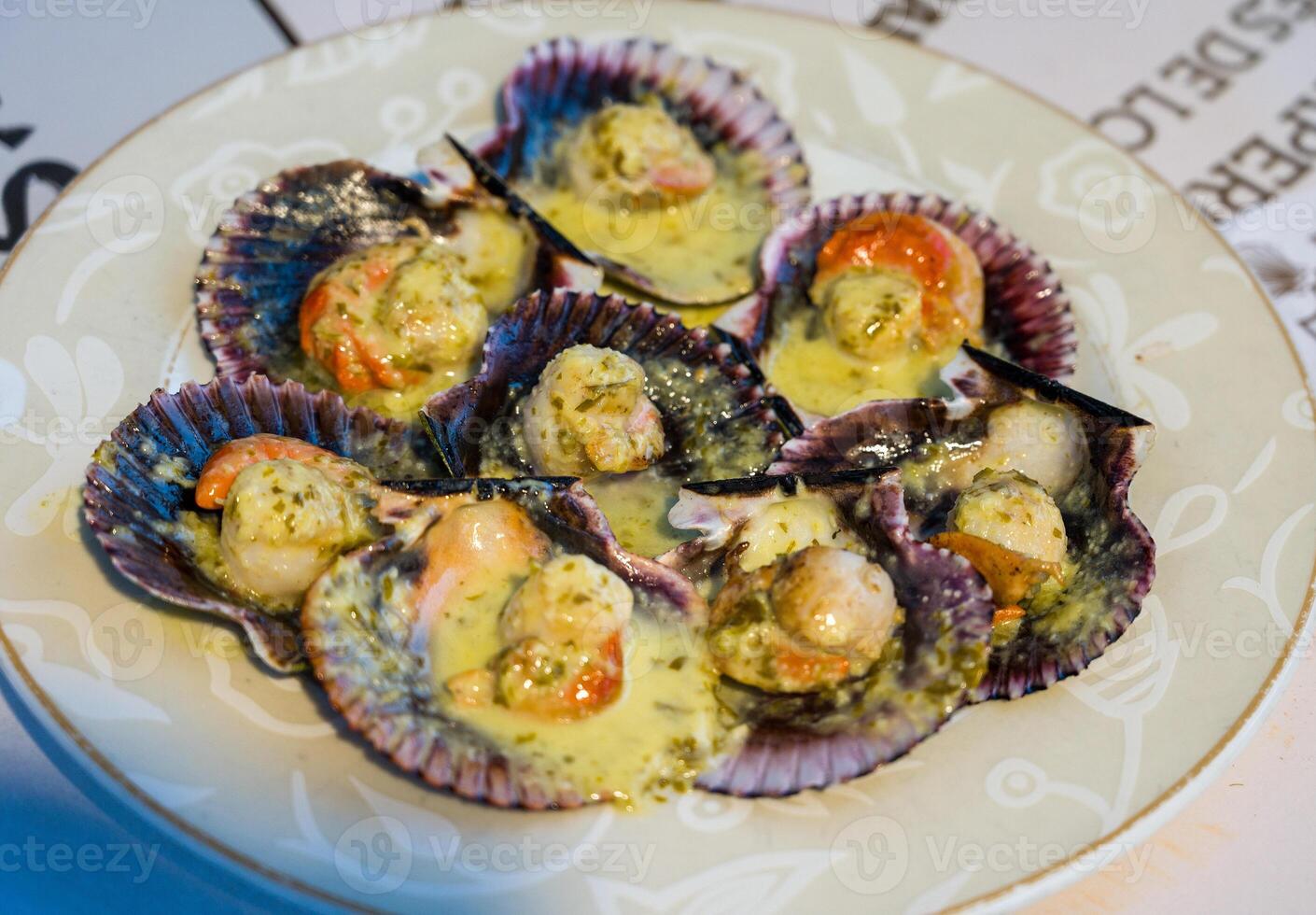 Grilled scallops with olive oil, garlic and parsley. Galician style of scallop dish Vieira. Typical Zamburinas dish from Galicia, spain, Delicious Spanish tapas food., photo