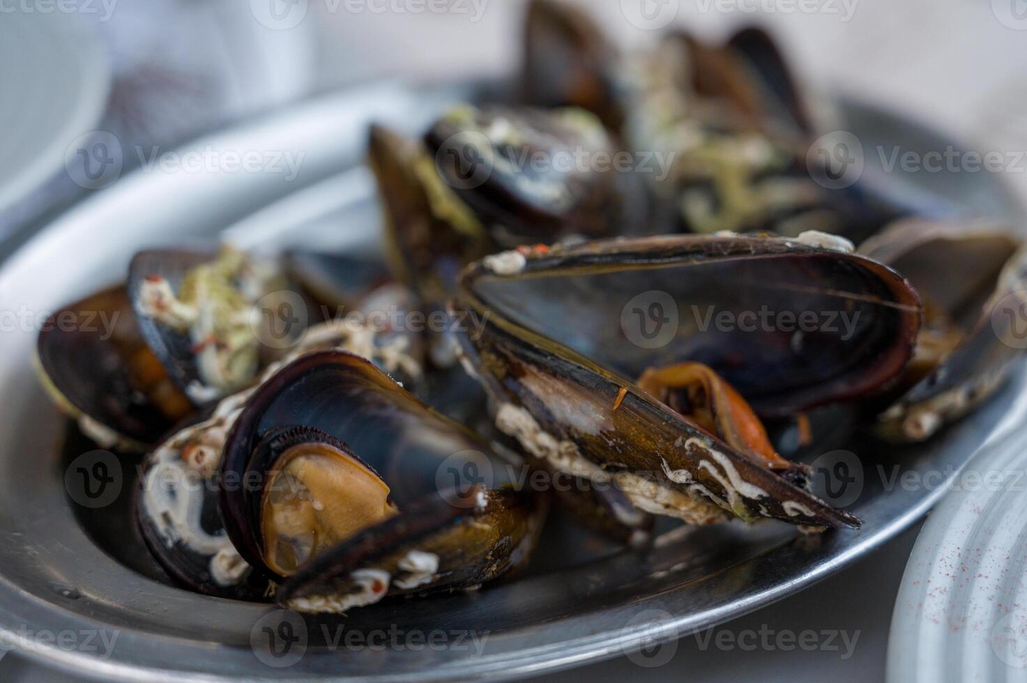 A delectable dish of fresh mussels served with a slice of lemon,. photo