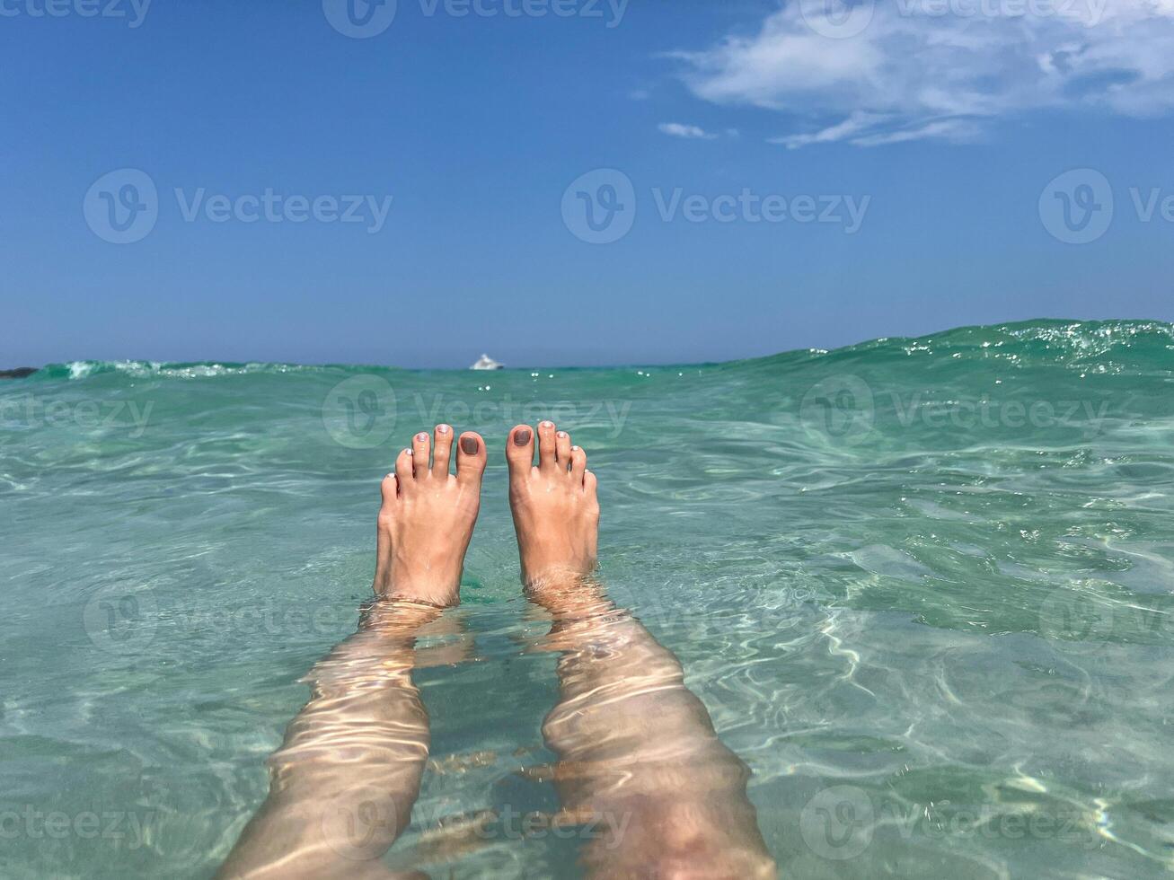 Woman's legs in sea water. Relaxation, summer freedom and tropical travel vacation concept photo