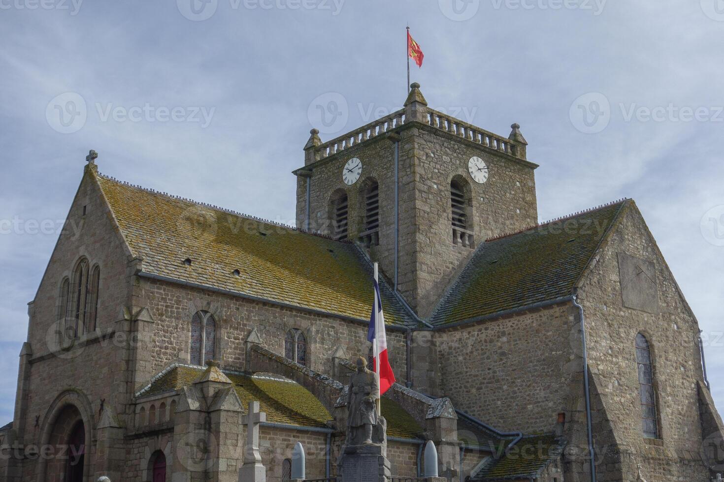 A large church with a clock tower in barfleur photo