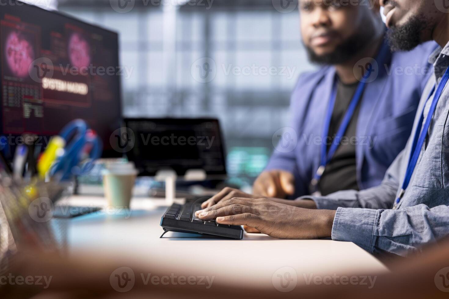 African american server farm worker trying to protect hardware from hacker attack stealing info. Man in data center workplace trying to get rid of virus after seeing security breach alert on display photo