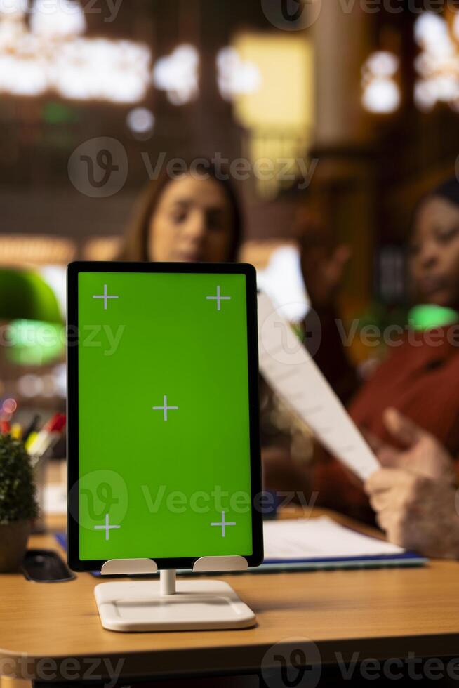 Diverse pupils group exchange notes next to chroma key at the campus library filled with books. Adults prepare academic materials for their thesis, deep focus and intellectual passion. photo