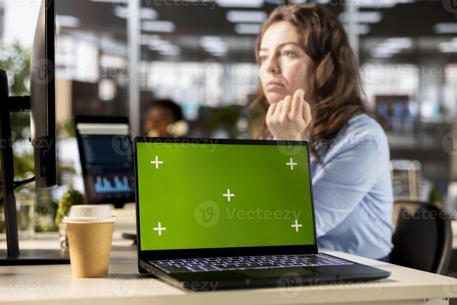 Professional office worker reviews financial plans next to mockup screen, using online tools on pc, problem solving and strategy planning tasks. Guaranteeing enterprise objectives. photo