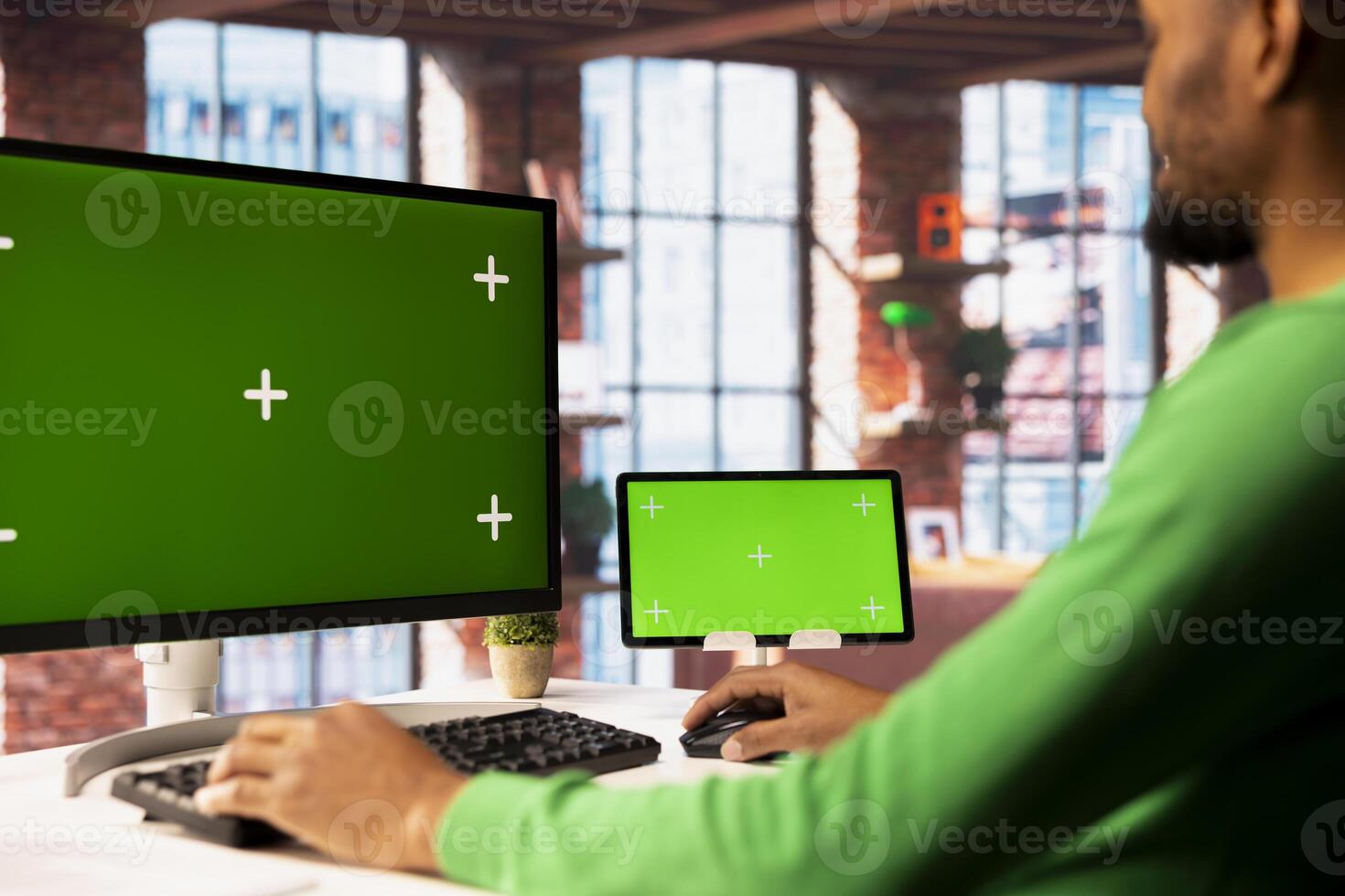 Man enjoying leisure time in living room , using isolated screen PC and tablet to text friends. African american person talking with mates on social network internet website using mockup devices photo