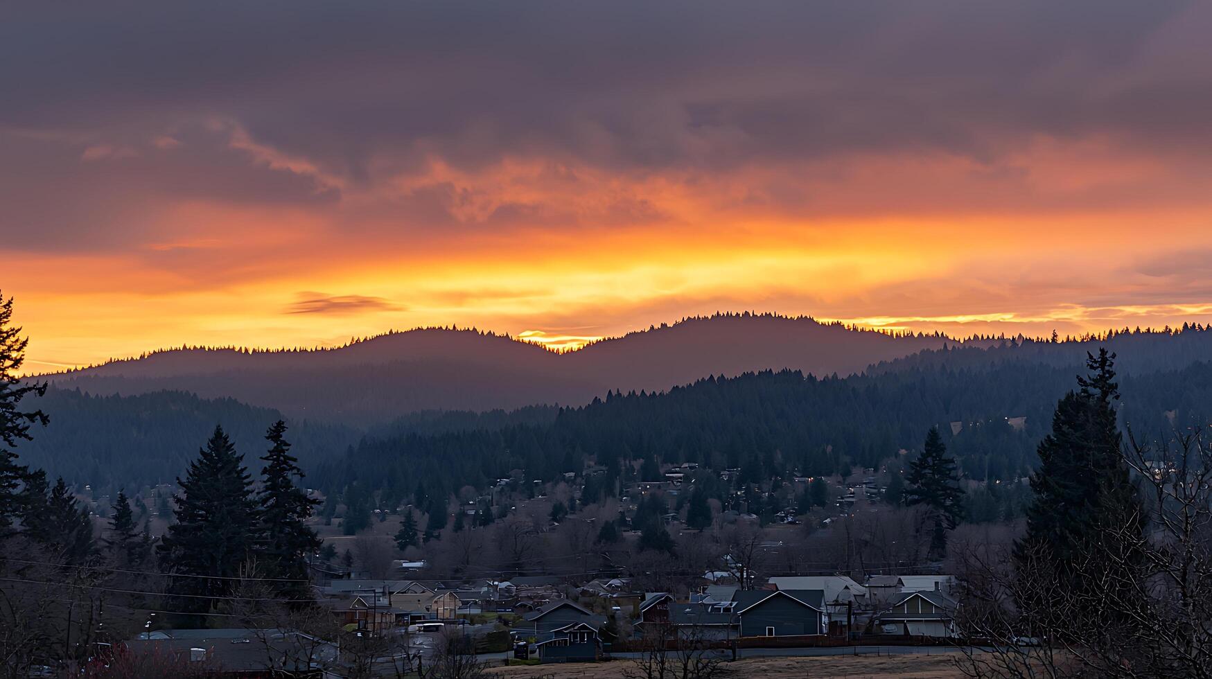 Dramatic Sunset Over Mountain Valley Town with Fiery Sky. photo