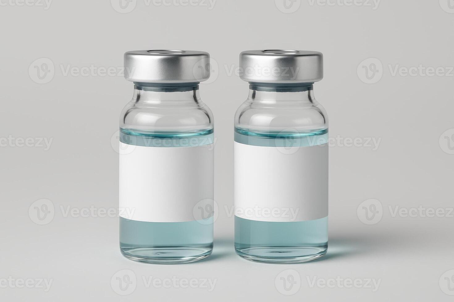 Pair of identical medical vials with silver caps and blank white labels filled with light blue liquid photo