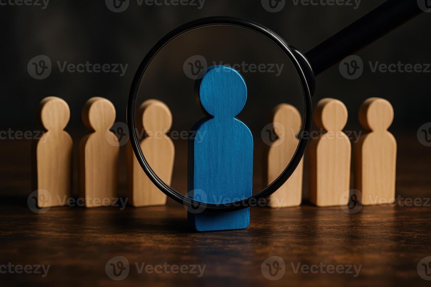 Magnifying glass highlighting a unique blue wooden figure, symbolizing selection and individuality photo