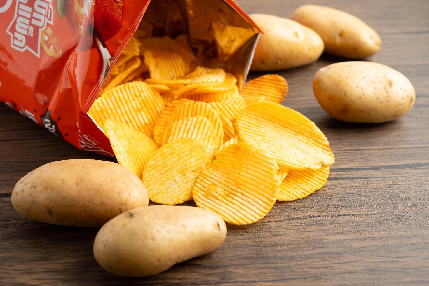 Bangkok, Thailand - May 15, 2022 Potato chips in open bag, delicious BBQ seasoning spicy for crips, thin slice deep fried snack fast photo