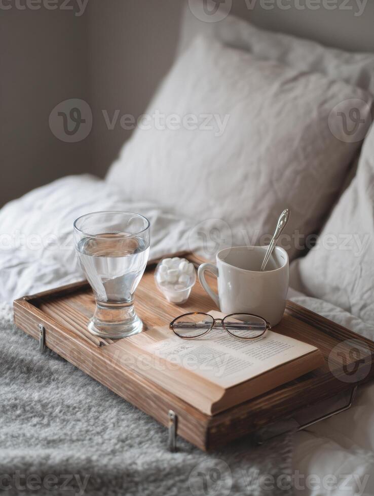 Cozy Recovery Setup on a Bed Tray With Medicine, Water, and a Book for a Chilly Day of Rest and Relaxation photo