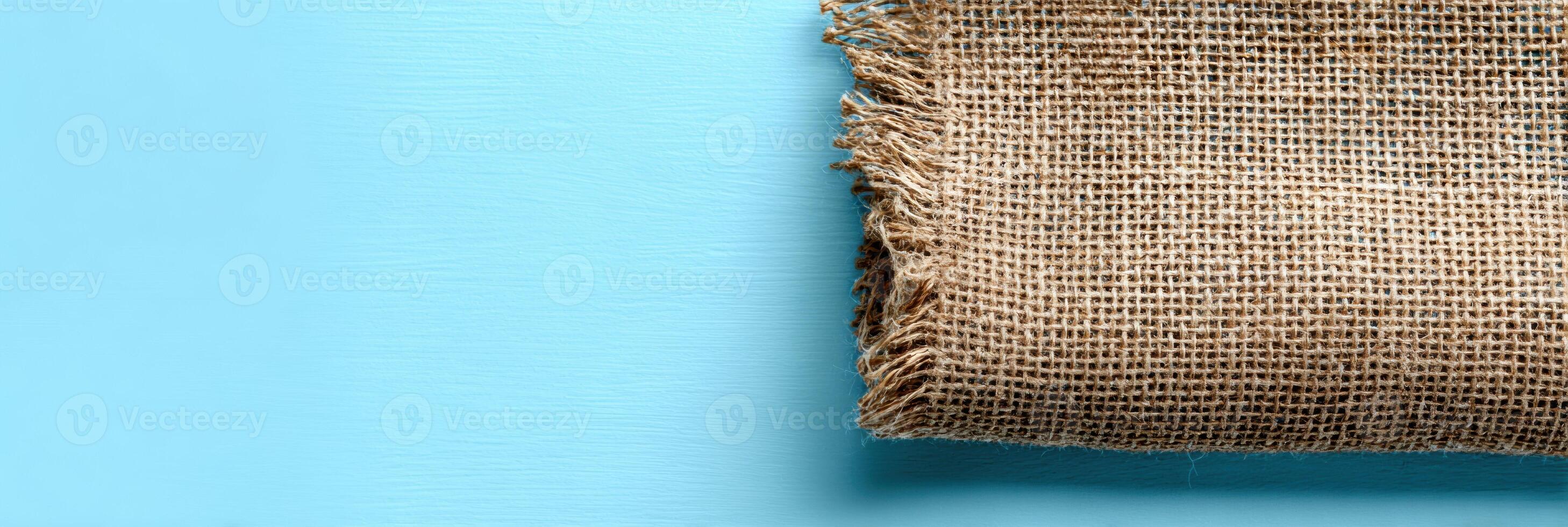 Eco-friendly Packaging Displayed on Burlap Cloth Against a Clean Sky-Blue Background Creates a Fresh and Sustainable Visual Appeal photo
