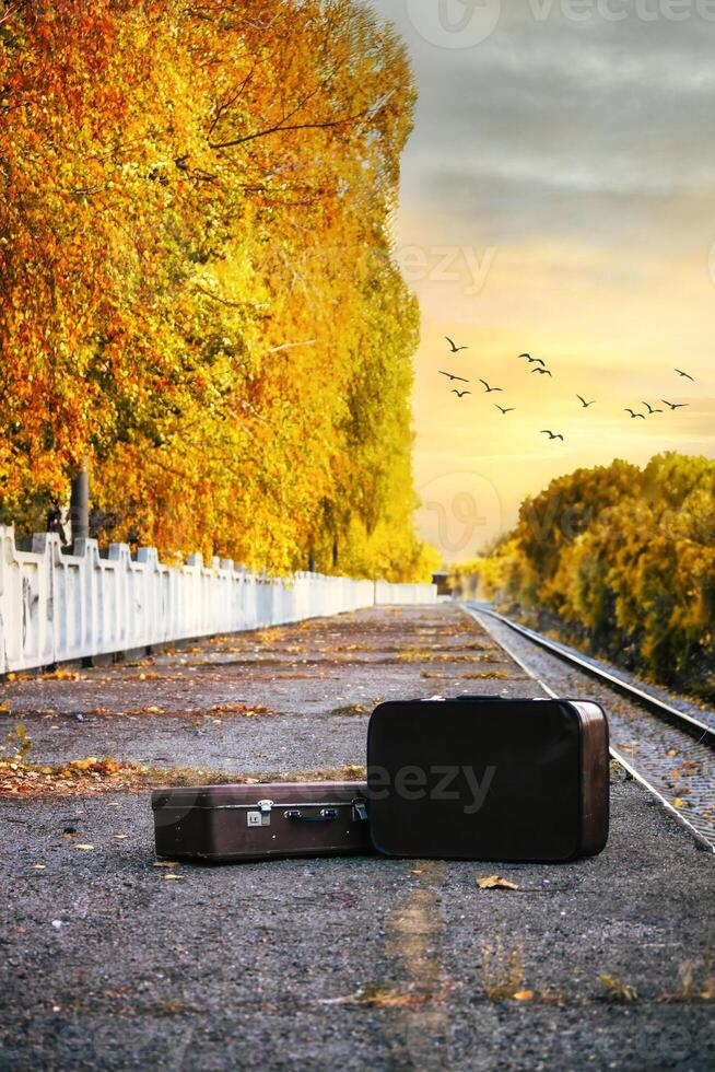 Two Suitcases On An Autumn Train Platform With Golden Trees At Sunset. photo