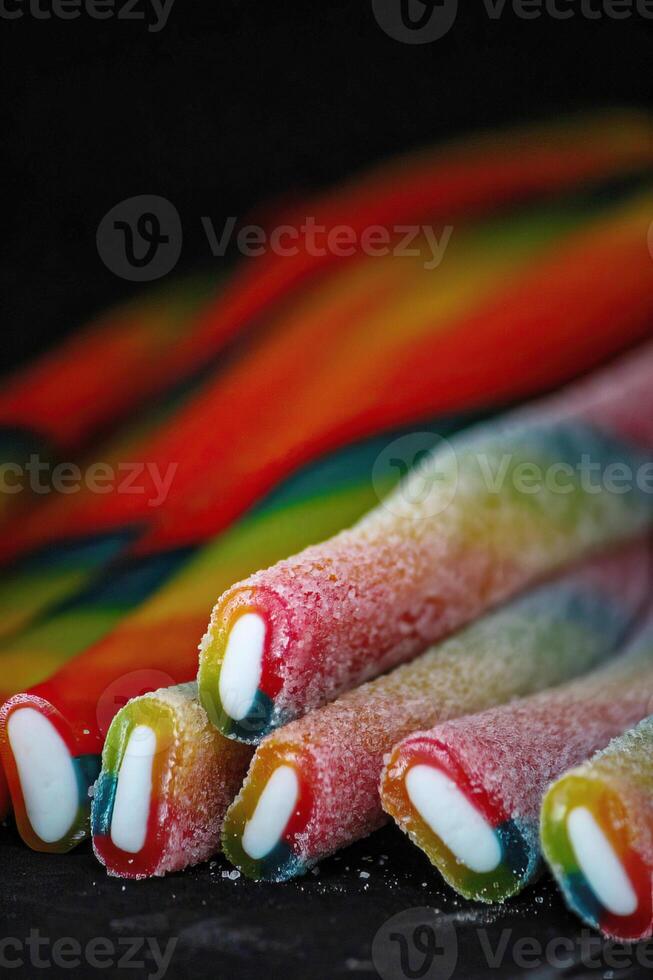 Colorful Long sticky jelly candies on black background, closeup of photo