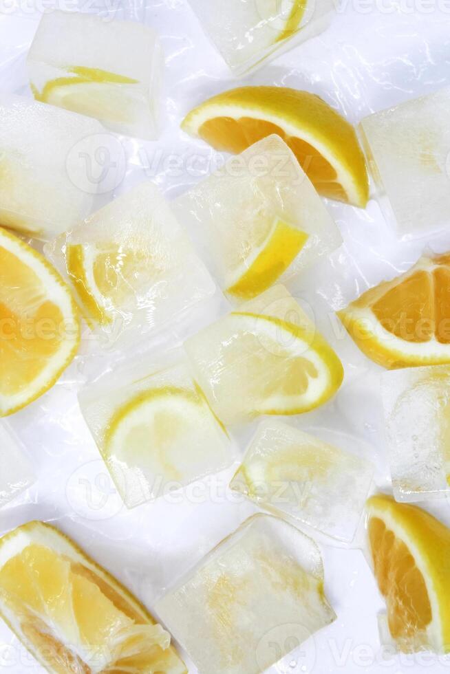 Top view of glistening ice cubes and juicy orange and lemon slices on white background. Refreshing concept. photo