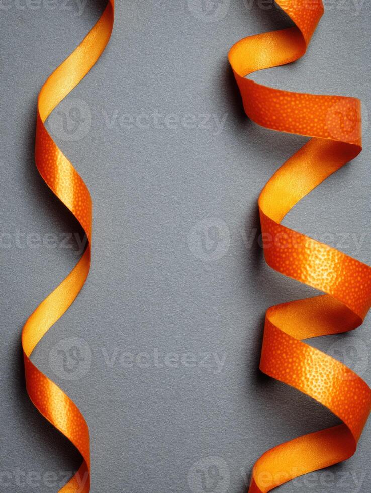 Floating Orange Zest Ribbon Creates a Vibrant Visual Against a Minimalistic Matte Background photo