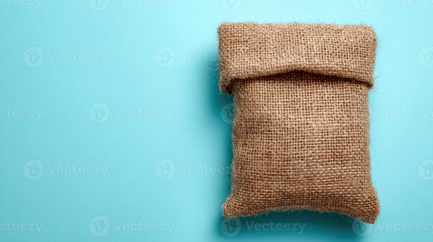 Eco-friendly Packaging on Burlap Cloth Against a Clean Sky-Blue Backdrop Showcasing Sustainable Choices in Product Design photo