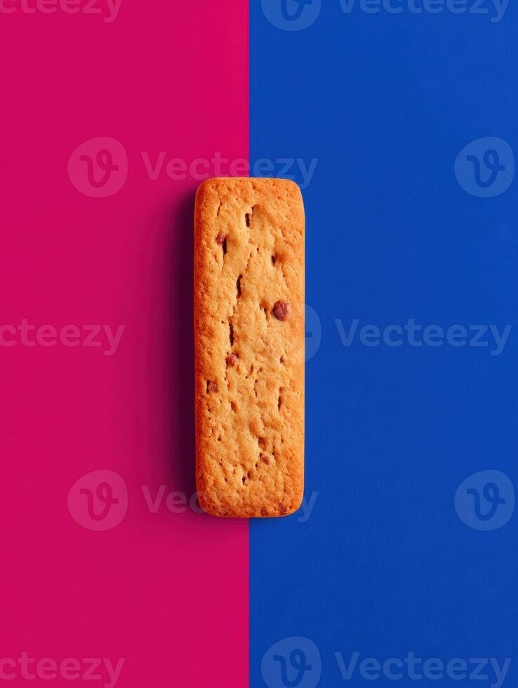 Colorful Pet Treat Advertisement Featuring a Biscuit on a Bold Pink and Blue Background photo
