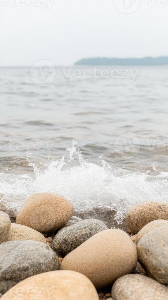 Coastal Serenity A Captivating Close-Up of Smooth Beach Pebbles Embraced by Gentle Ocean Waves and Sparkling Water Splashes on a Peaceful Shoreline photo