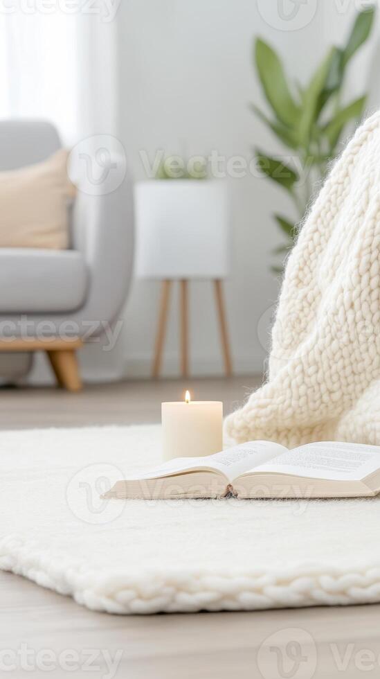Cozy Home Sanctuary A Serene Scene of Comfort and Relaxation with a Lit Candle, Open Book, and Soft Blanket in a Tranquil Living Space photo