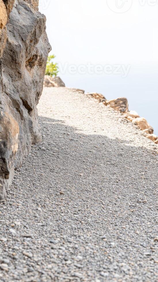 A Serene Gravel Path Winding Along a Rugged Cliff Edge, Inviting Exploration Through Nature's Textured Landscape and Tranquil Vistas. photo