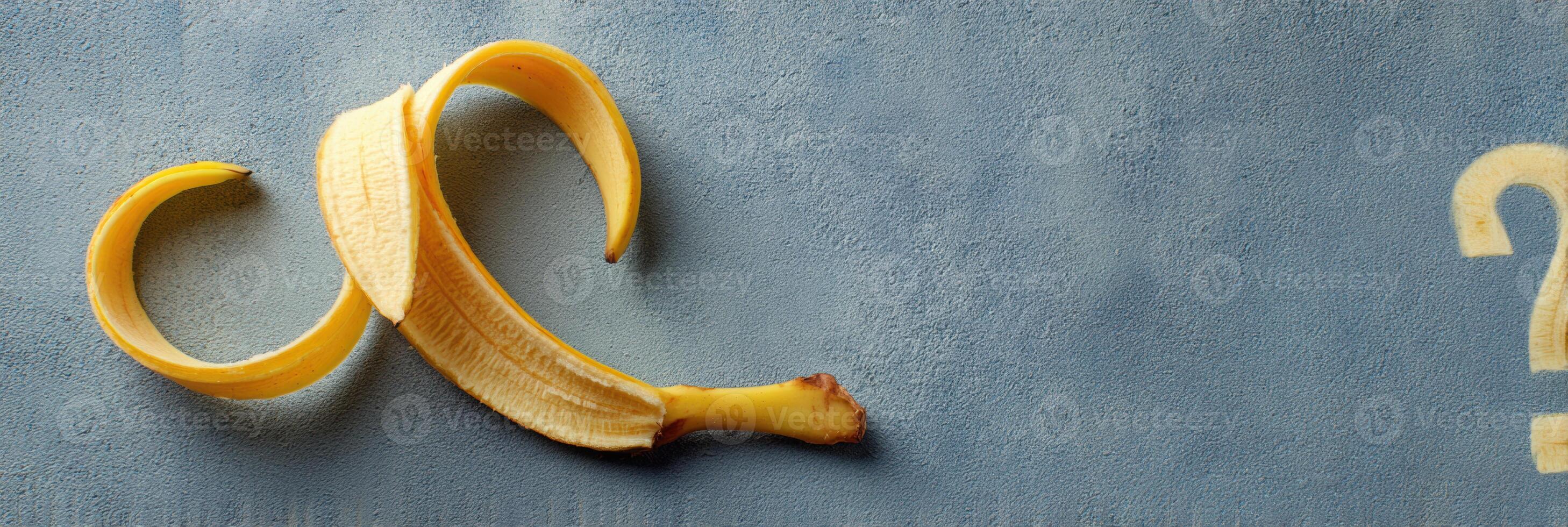 Curled Banana Peel Forms a Whimsical Question Mark Shape on a Smooth Surface photo