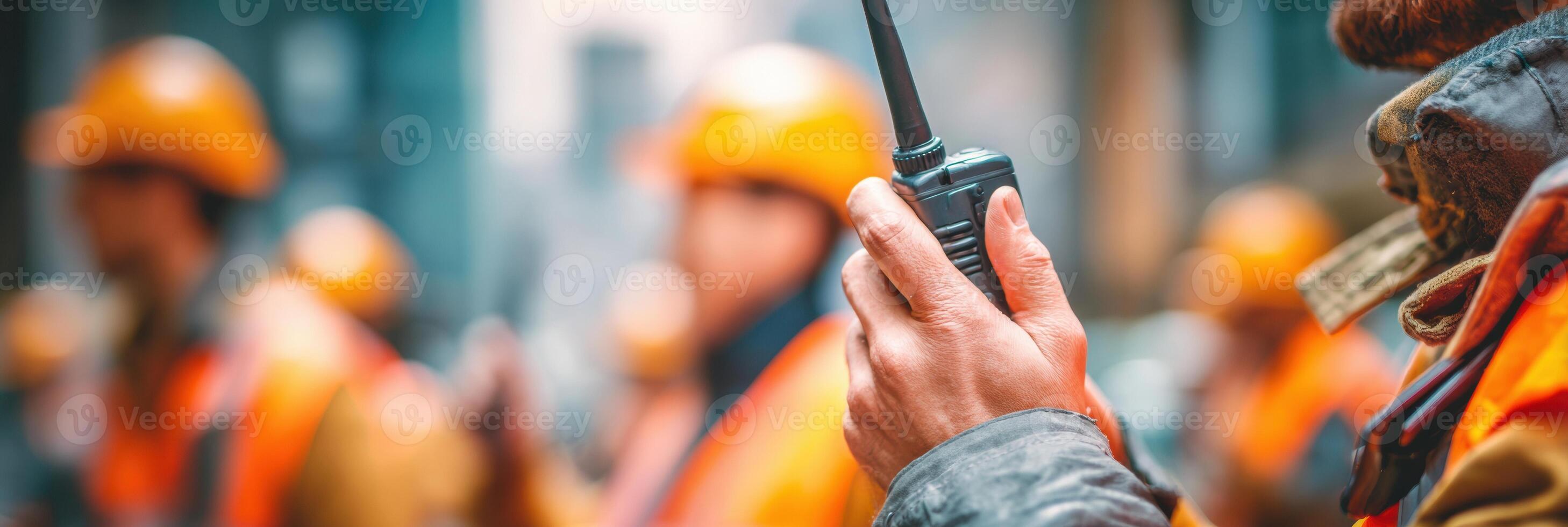 Man Holding Walkie-Talkie Communicates During Teamwork Execution in Construction Site Environment With Blurred Background photo