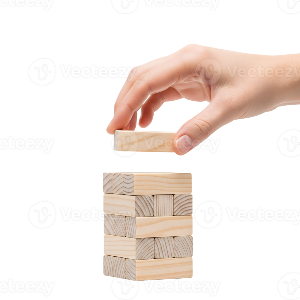 A hand carefully places a wooden block on a tower isolated on transparent background png