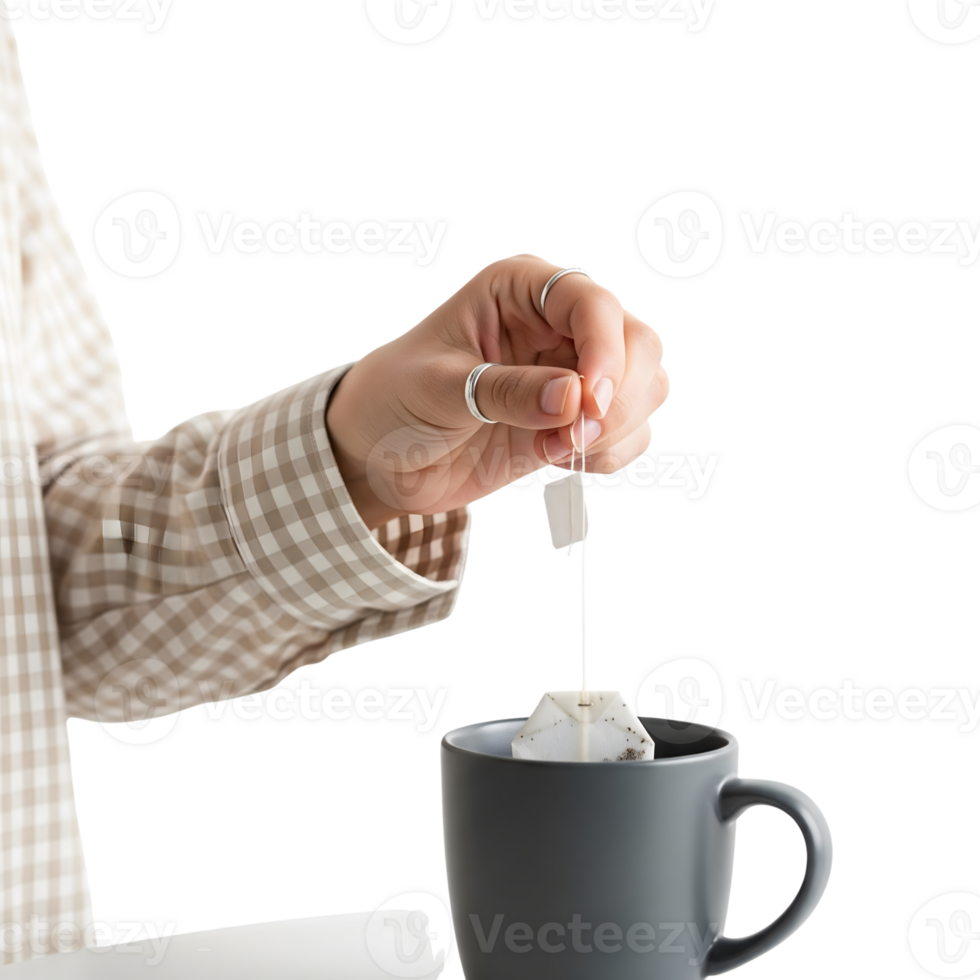 A hand holds a teabag over a gray mug, isolated on transparent background, ready to steep a comforting and warm beverage png