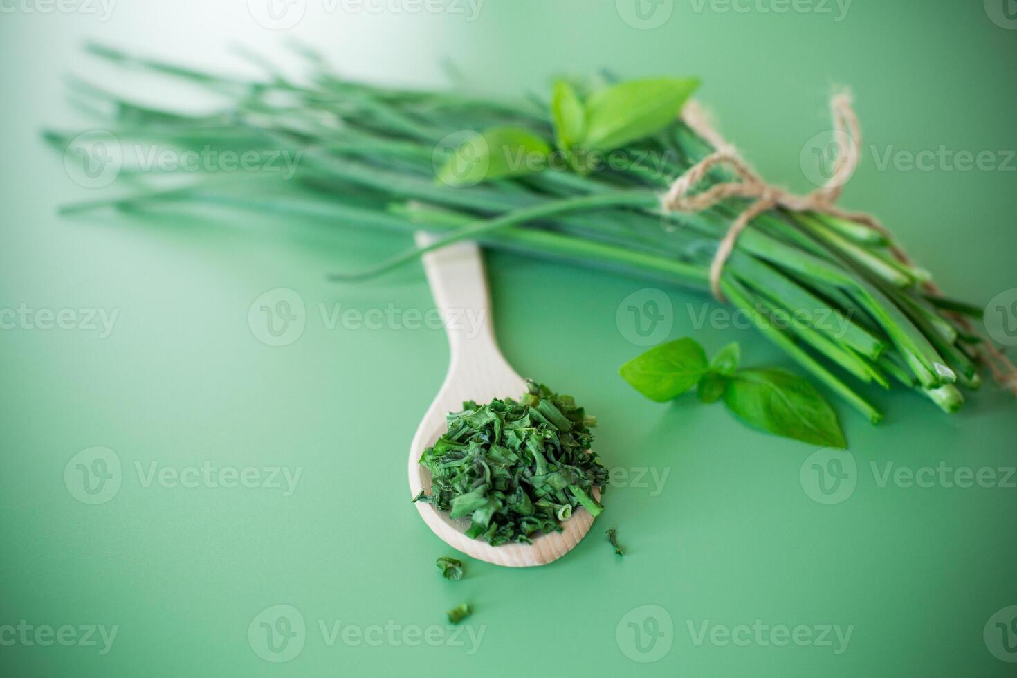 Natural seasonings from greens and onions on green background photo