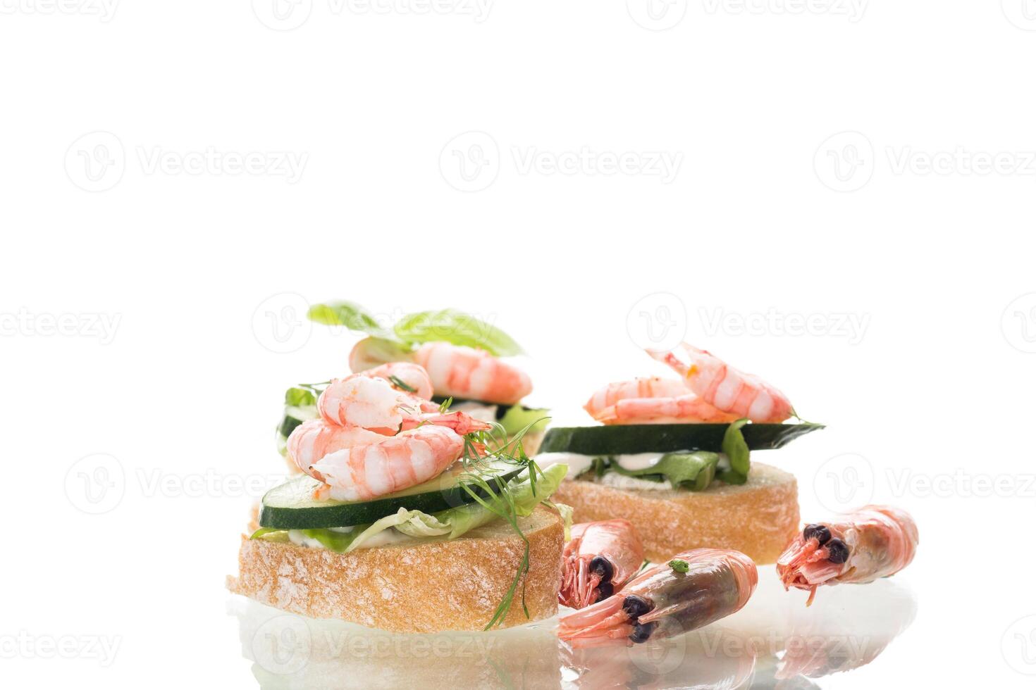 Delicious portioned appetizers with shrimps and greens on a white background photo