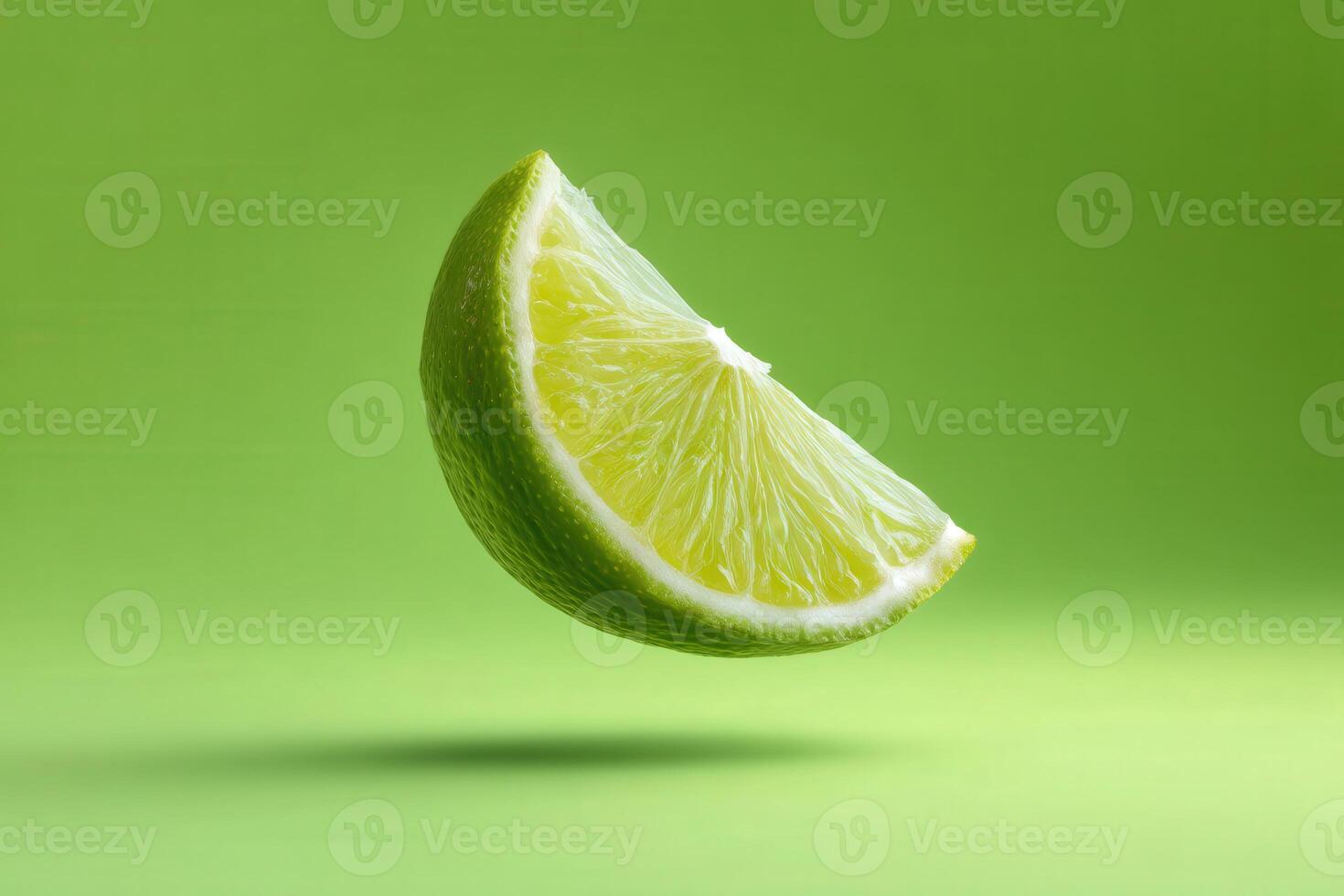 Floating wedge of green lime on green backdrop photo