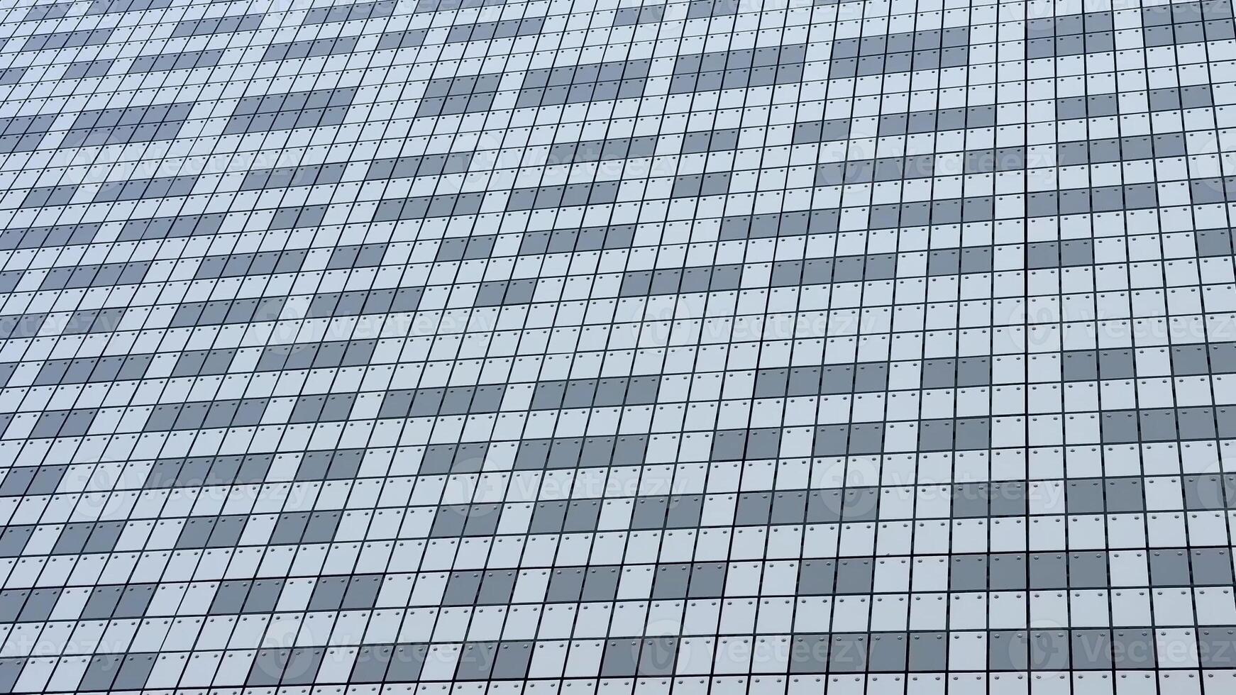 The stylish and striking facade of a modern building showcases a beautiful mosaic composed of gray and white tiles photo