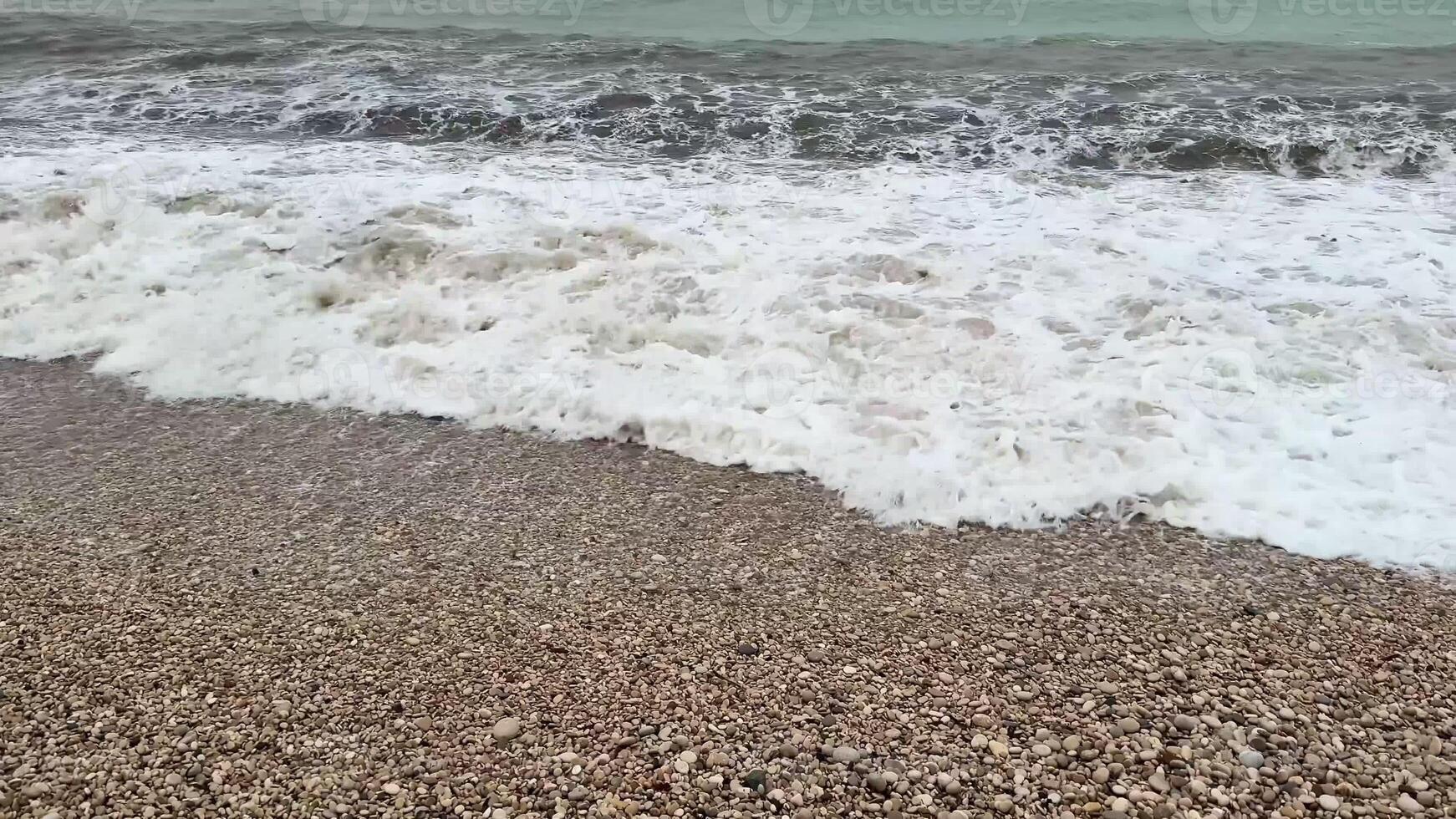 A truly captivating scene showcasing gentle ocean waves gracefully crashing onto a stunning, pebbly beach photo