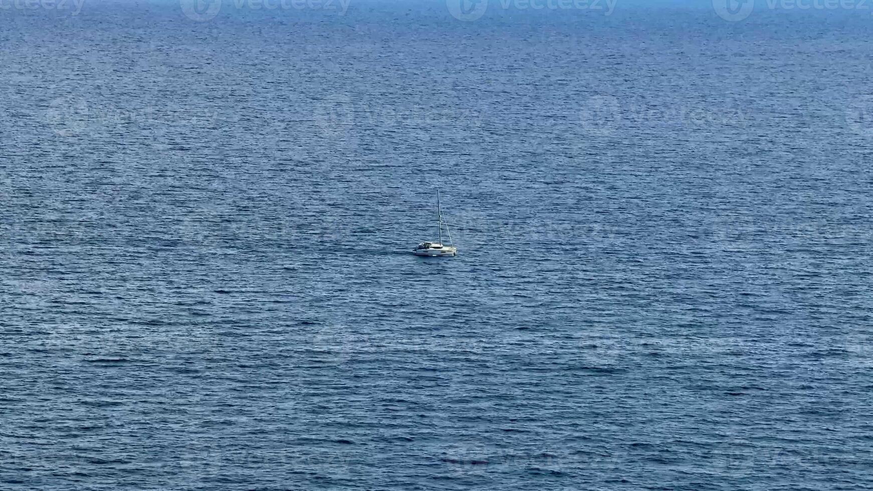 A boat effortlessly glides gracefully across the tranquil blue waters, evoking a strong sense of peace and solitude photo