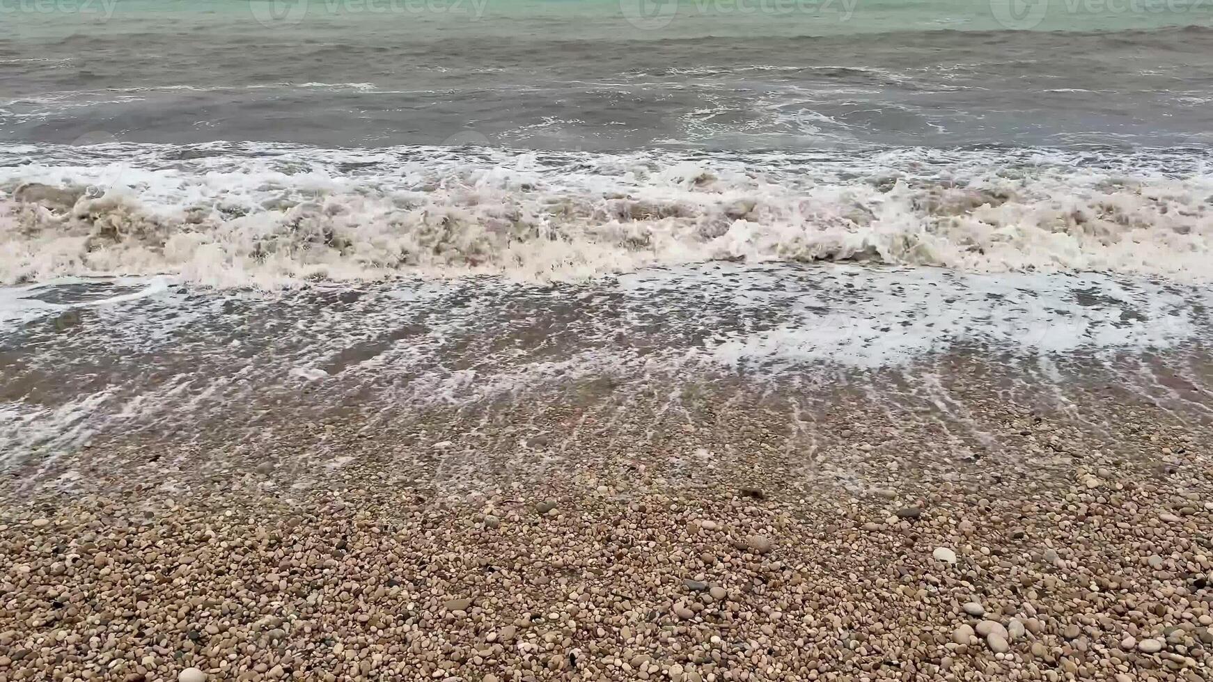 Gentle waves rhythmically crashing upon a lovely pebble beach, beautifully showcasing natures serene allure and charm photo