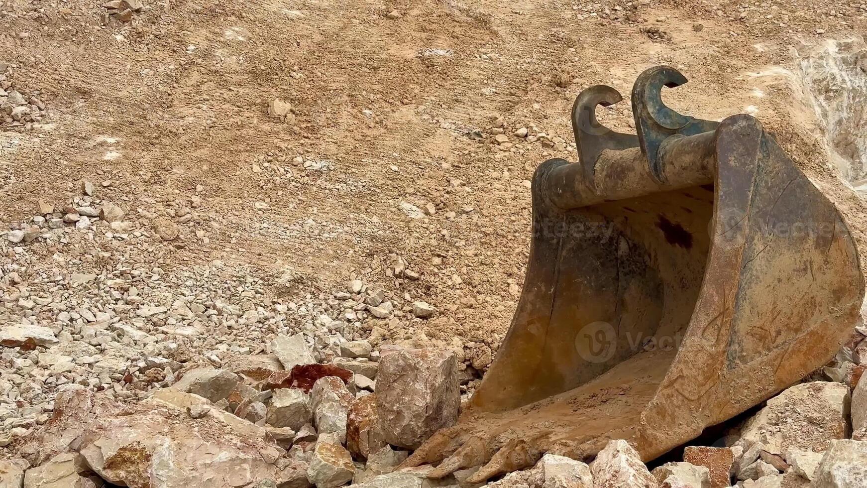 A thorough and detailed view of an excavation site showcasing heavy machinery alongside various rock formations photo