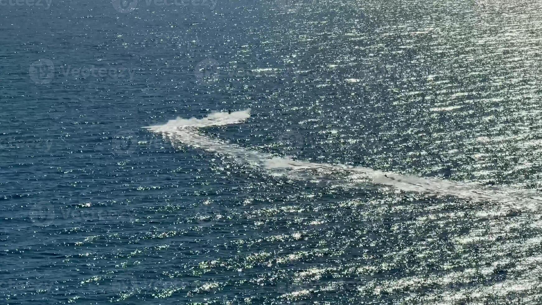 Experience dynamic aerial shots capturing the thrilling jet ski trails gliding on a shimmering ocean surface photo