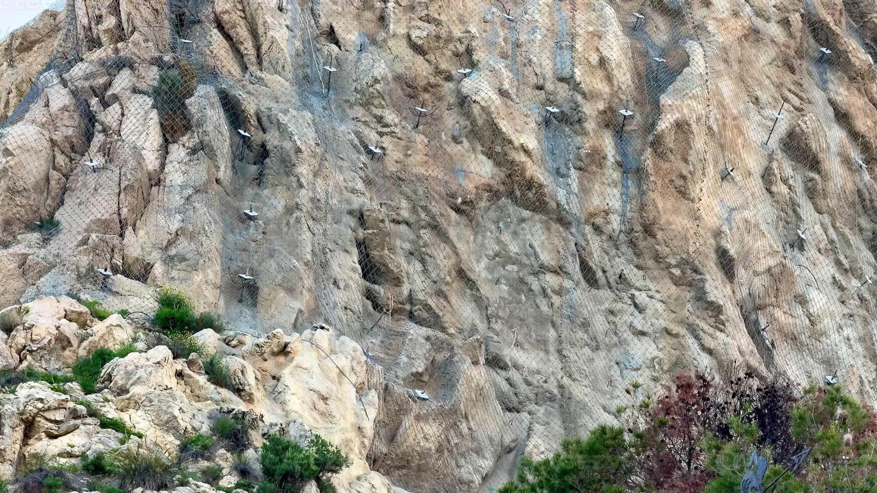 A majestic rocky cliff with safety measures for climbers and protection for the surrounding natural habitat photo