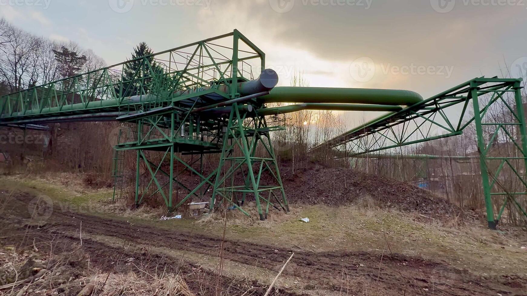 A striking industrial structure featuring a green pipeline against a cloudy sky, showcasing engineering marvel. photo