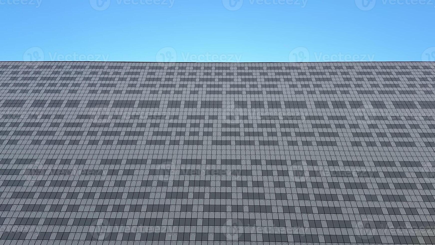 Appreciate this stunning view of a modern buildings textured facade against a vibrant blue sky, a treat for architects photo